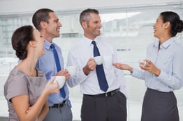 Cheerful work team during break time in bright office